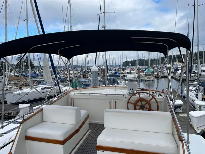  Yacht Photos Pics 1980 Grand Banks 42 Europa yacht interior at marina, featuring helm and seating area.