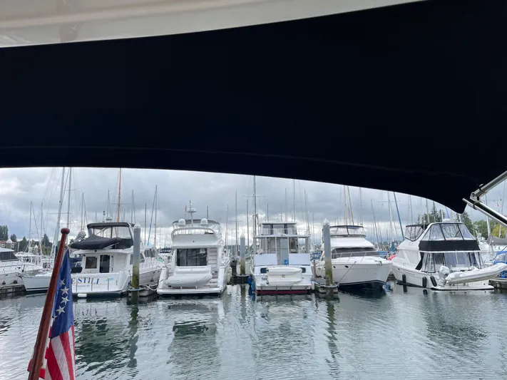  Yacht Photos Pics Marina view with various yachts, including a 1980 Grand Banks 42 Europa, under a dark canopy.