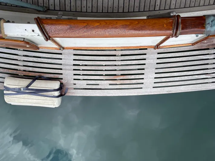  Yacht Photos Pics Grand Banks 42 Europa 1980 boat deck with wooden railing and water reflection.