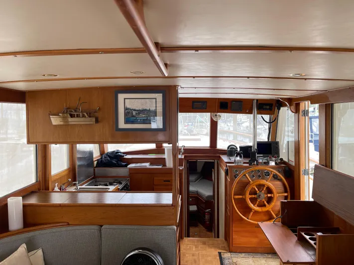  Yacht Photos Pics Interior of 1980 Grand Banks 42 Europa yacht with wooden helm and cozy seating area.