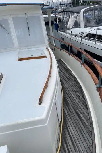  Yacht Photos Pics 1980 Grand Banks 42 Europa yacht docked, featuring wooden deck and railing.