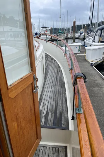  Yacht Photos Pics 1980 Grand Banks 42 Europa yacht docked at marina, wooden deck and railing visible.