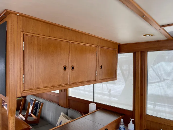  Yacht Photos Pics Interior of 1980 Grand Banks 42 Europa with wooden cabinets and seating area.