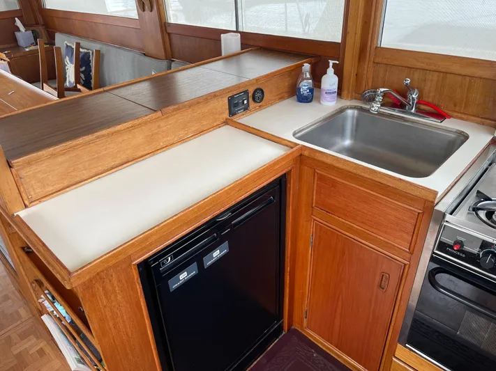  Yacht Photos Pics 1980 Grand Banks 42 Europa yacht kitchen with sink, stove, and mini fridge.