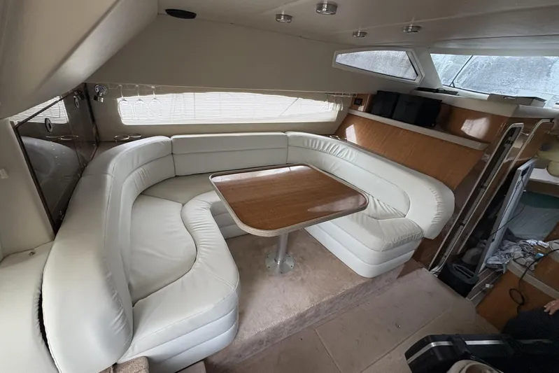  Yacht Photos Pics Luxurious interior of 2003 Regal Commodore 3880 yacht with white leather seating and wooden table.