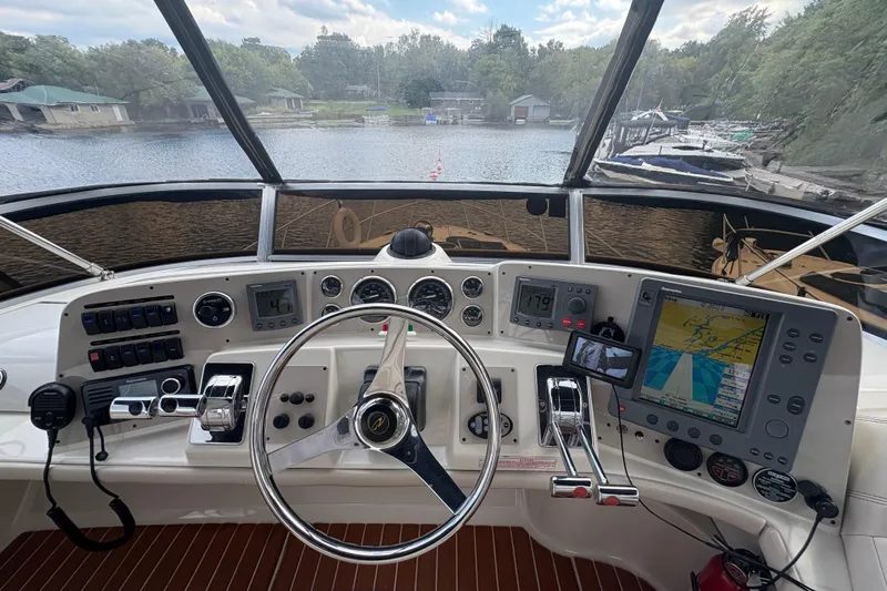  Yacht Photos Pics Helm of 2003 Regal Commodore 3880 with navigation equipment and controls, docked by a scenic lake.