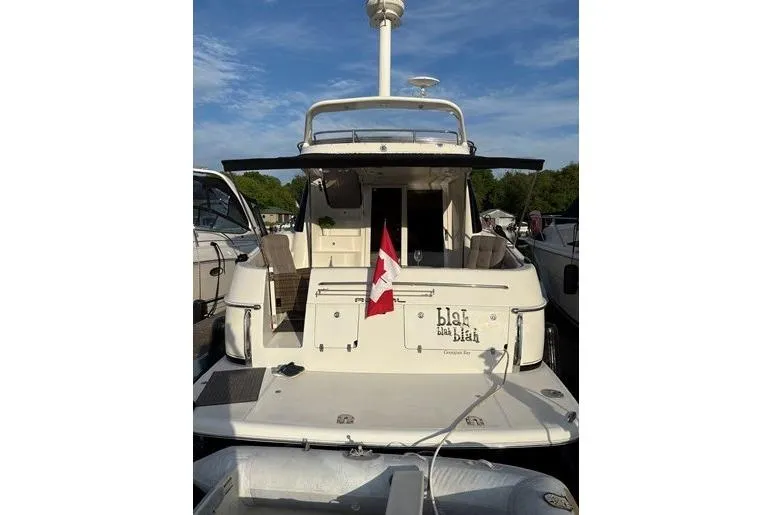  Yacht Photos Pics 2003 Regal Commodore 3880 yacht with Canadian flag, docked under clear sky.