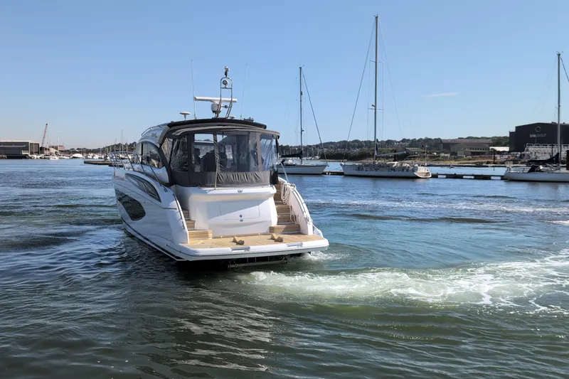  Yacht Photos Pics 2021 Princess V50 yacht cruising in a marina with sailboats in the background.