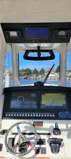 Carly Rose Yacht Photos Pics 2023 Regulator 34 boat dashboard with navigation screens and steering wheel.