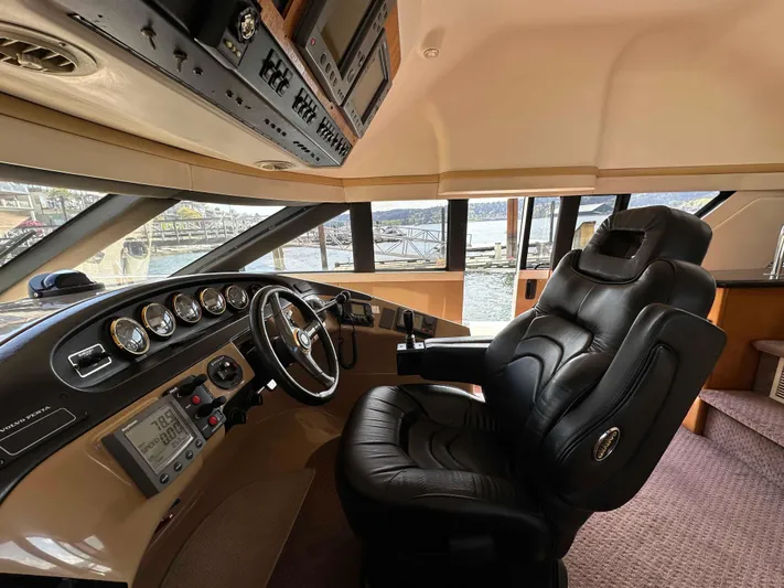  Yacht Photos Pics Pilothouse interior of 2001 Carver 570 Voyager, featuring a luxurious captain's chair and control panel.