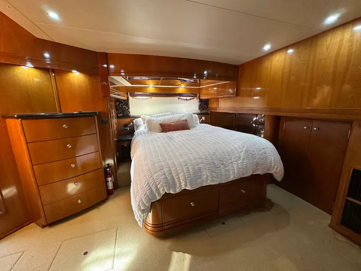  Yacht Photos Pics Luxurious bedroom interior of 2001 Carver 570 Voyager Pilothouse yacht with wood paneling.