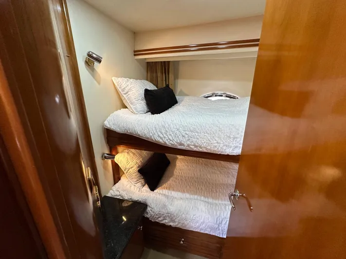  Yacht Photos Pics Bunk beds in 2001 Carver 570 Voyager Pilothouse cabin, featuring cozy bedding and wooden accents.