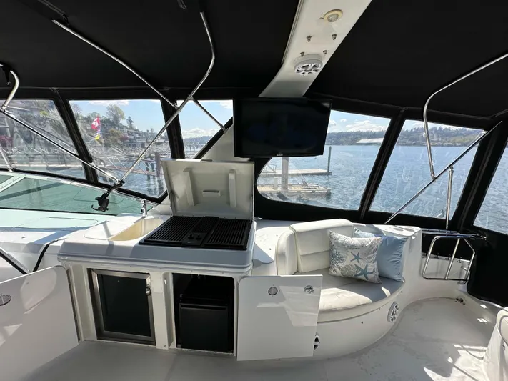  Yacht Photos Pics 2001 Carver 570 Voyager Pilothouse interior with seating, grill, and waterfront view.