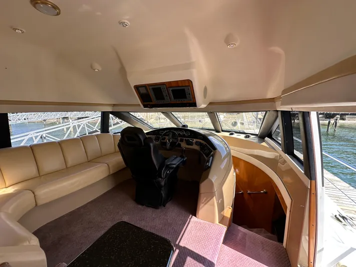  Yacht Photos Pics Interior of 2001 Carver 570 Voyager Pilothouse with helm, seating, and panoramic windows.