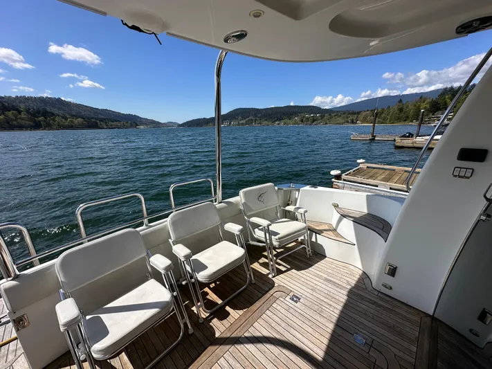  Yacht Photos Pics 2001 Carver 570 Voyager Pilothouse deck with chairs, overlooking scenic water and hills.