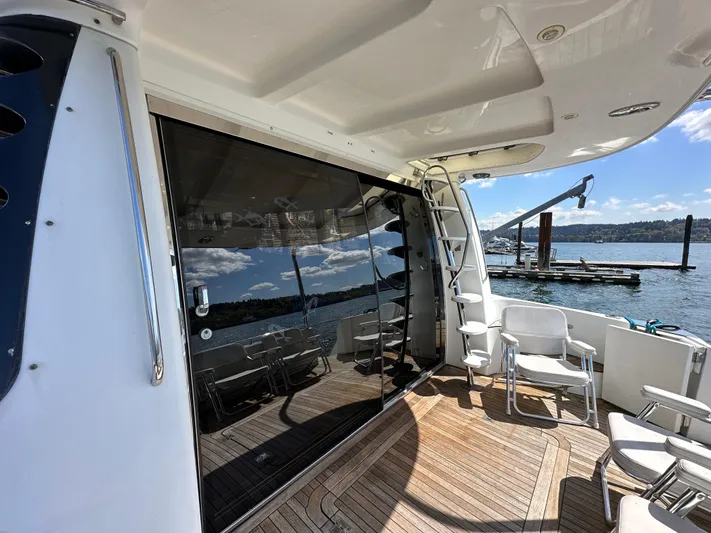  Yacht Photos Pics 2001 Carver 570 Voyager Pilothouse yacht deck with seating, overlooking a serene waterfront.