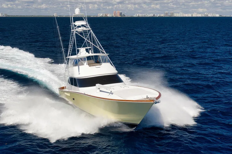 Monkey Business Yacht Photos Pics 2010 Viking 82 Convertible yacht cruising on open ocean with city skyline in background.