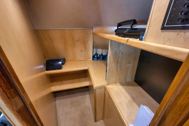 Monkey Business Yacht Photos Pics Wooden interior workspace on 2010 Viking 82 Convertible yacht with shelves and electronic devices.