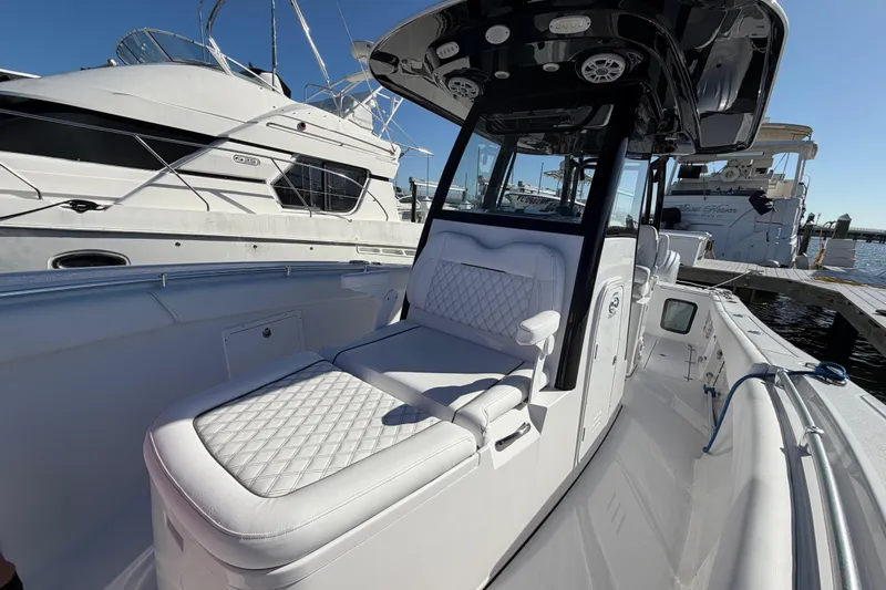  Yacht Photos Pics 2024 Sportsman Open 282TE Center Console boat with luxurious seating at a marina.