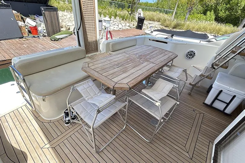 2008 Ferretti 510 Fly @ Cancun Yacht Photos Pics Outdoor seating area on 2008 Ferretti Yachts 510, featuring wooden table and chairs.