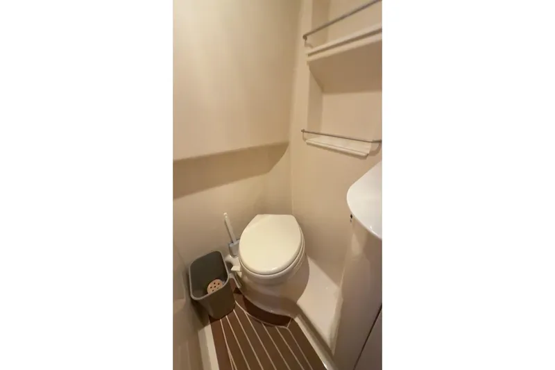  Yacht Photos Pics 2017 Sea Ray 330 Sundancer bathroom with toilet, shelves, and wooden floor.