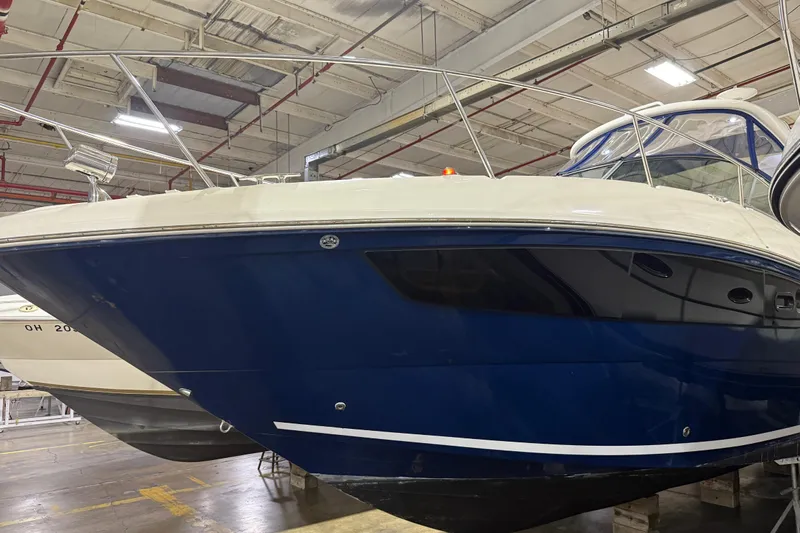  Yacht Photos Pics 2017 Sea Ray Sundancer 330 boat in indoor storage, blue hull, sleek design.