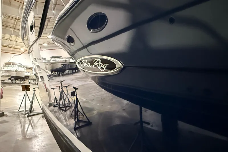  Yacht Photos Pics 2017 Sea Ray Sundancer 330 yacht in a showroom, showcasing sleek design and logo.