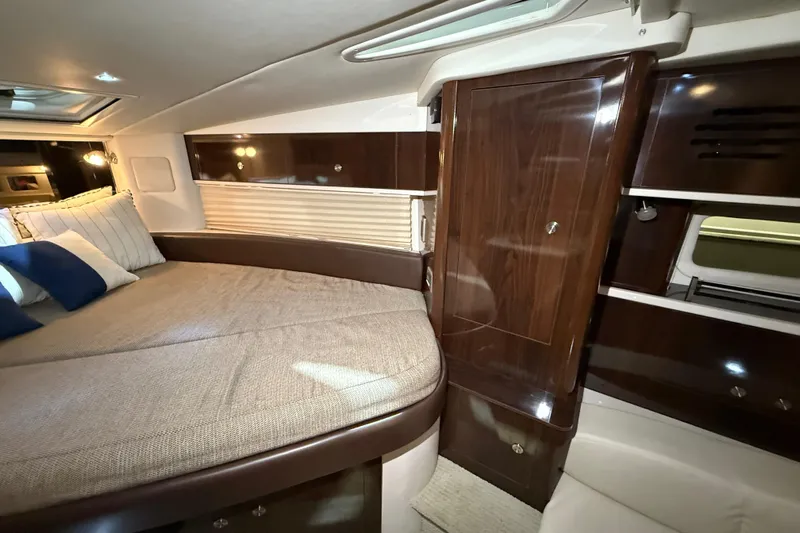  Yacht Photos Pics Luxurious interior of 2017 Sea Ray Sundancer 330 with elegant wood finishes and cozy bedding.