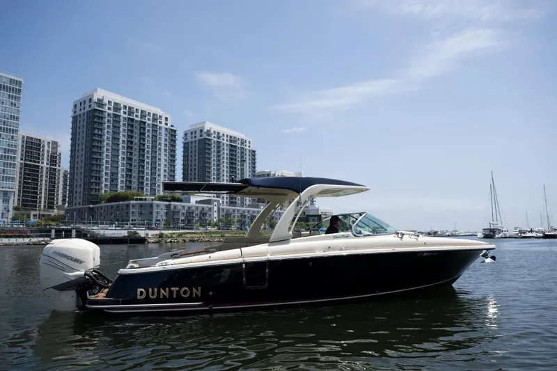 Dunton Yacht Photos Pics 2021 Chris-Craft Launch GT boat on water, city skyline in background.
