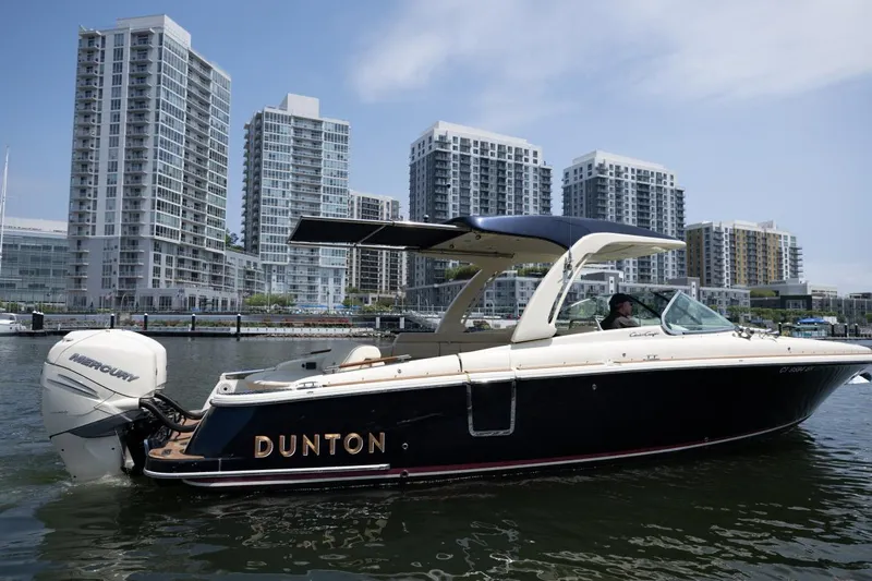 Dunton Yacht Photos Pics 2021 Chris-Craft Launch GT boat on water with city skyline in background.