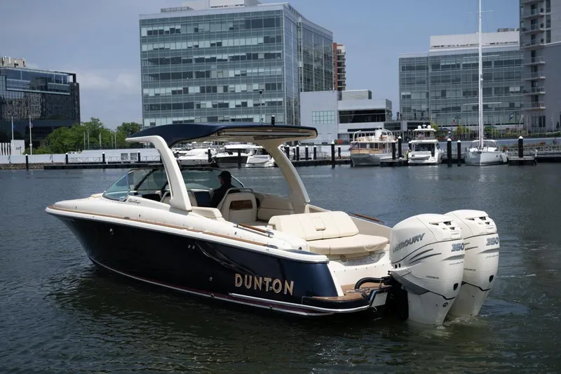 Dunton Yacht Photos Pics 2021 Chris-Craft Launch GT boat docked in urban marina with modern buildings.