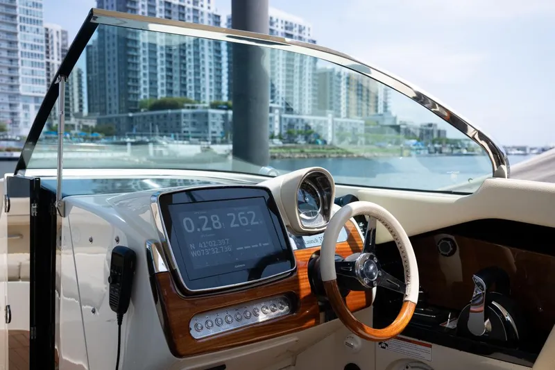 Dunton Yacht Photos Pics 2021 Chris-Craft Launch GT dashboard with cityscape view, featuring modern controls and steering wheel.