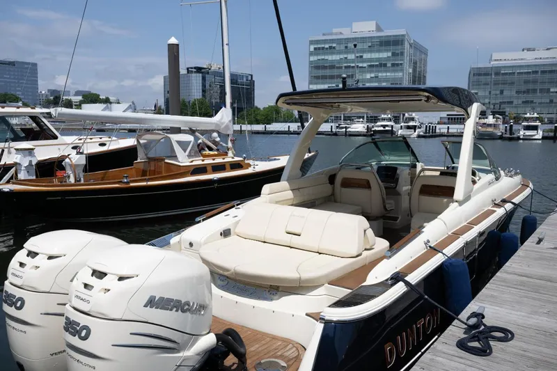 Dunton Yacht Photos Pics 2021 Chris-Craft Launch GT boat docked, featuring luxurious seating and twin Mercury engines.