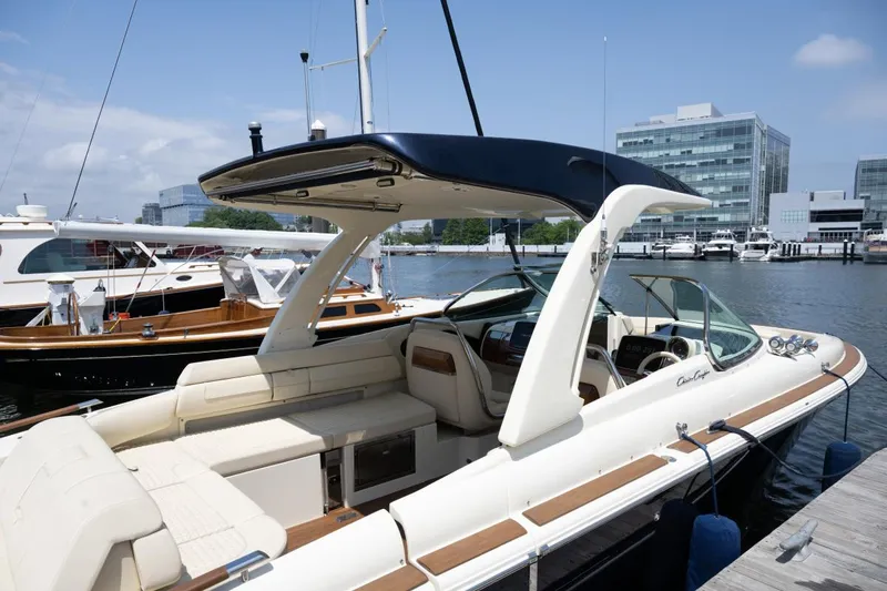 Dunton Yacht Photos Pics 2021 Chris-Craft Launch GT boat docked at marina, featuring sleek design and luxurious seating.