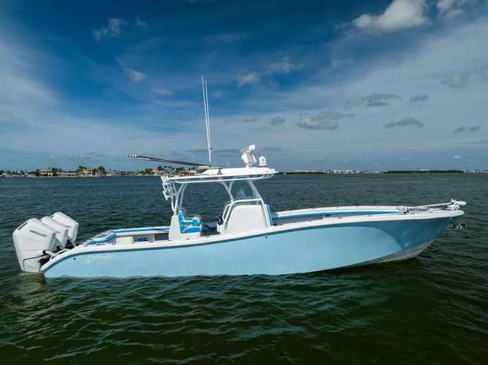  Yacht Photos Pics 2023 Yellowfin 36 Offshore boat on calm water under a blue sky.