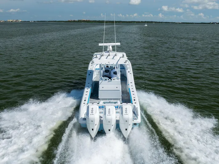  Yacht Photos Pics 2023 Yellowfin 36 Offshore boat speeding on open water, rear view.