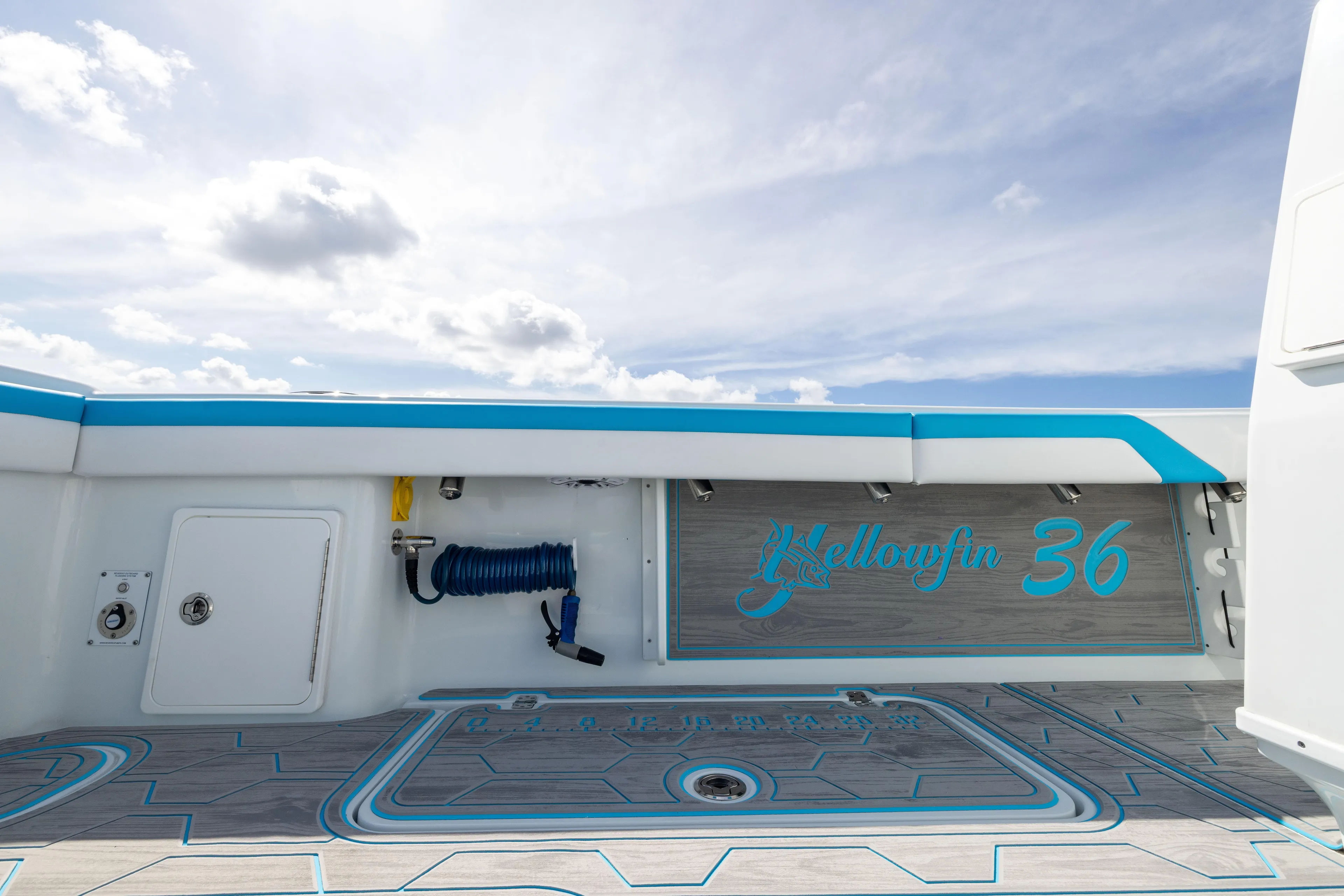  Yacht Photos Pics 2023 Yellowfin 36 Offshore boat deck with blue accents under a cloudy sky.