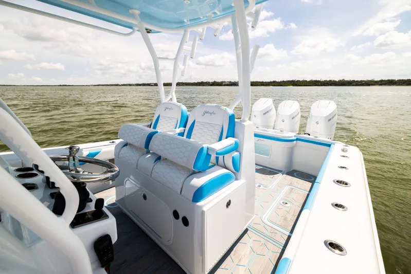  Yacht Photos Pics 2023 Yellowfin 36 Offshore boat interior with blue and white seating, steering wheel, and multiple engines.