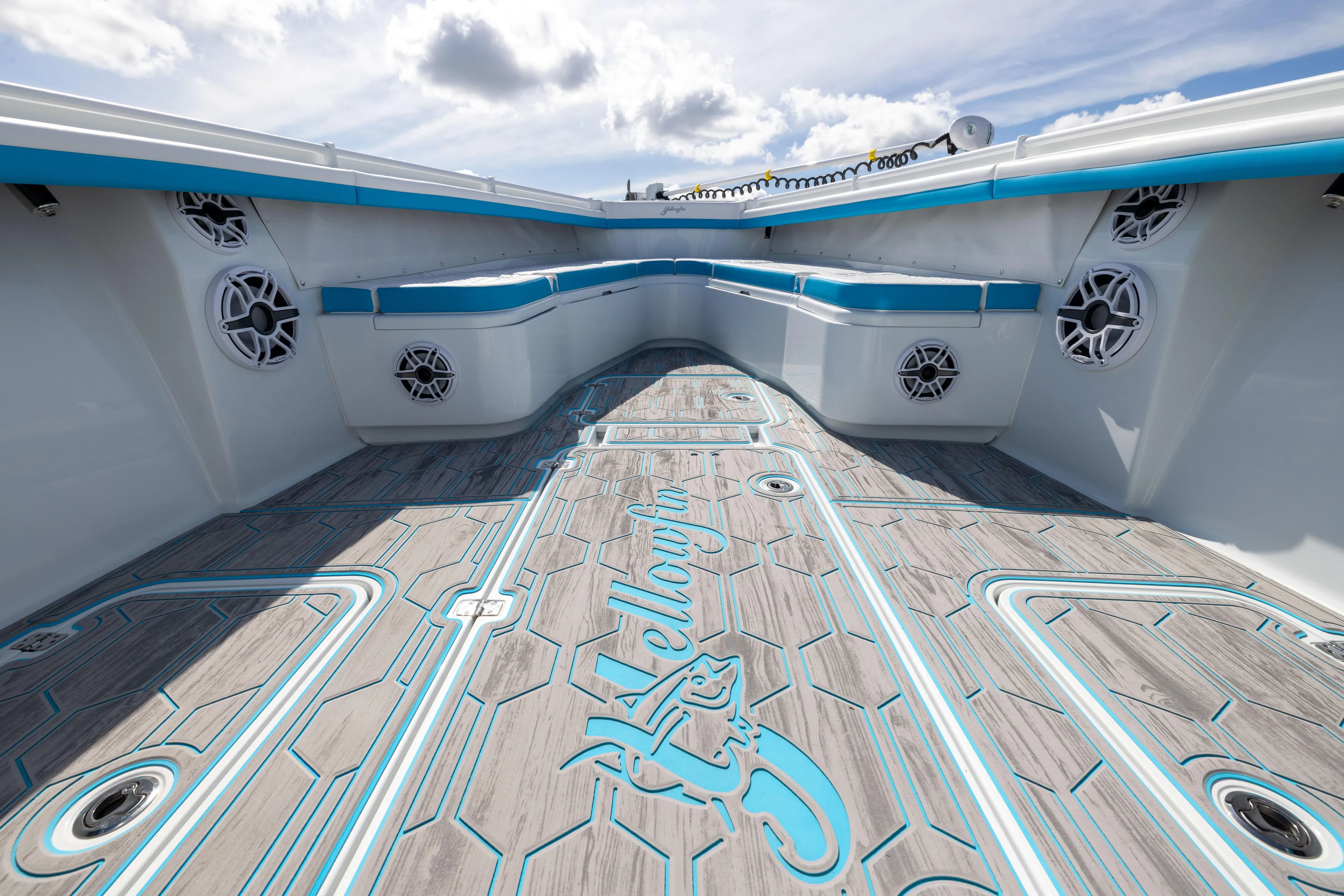  Yacht Photos Pics 2023 Yellowfin 36 Offshore boat interior with stylish flooring and seating under a cloudy sky.