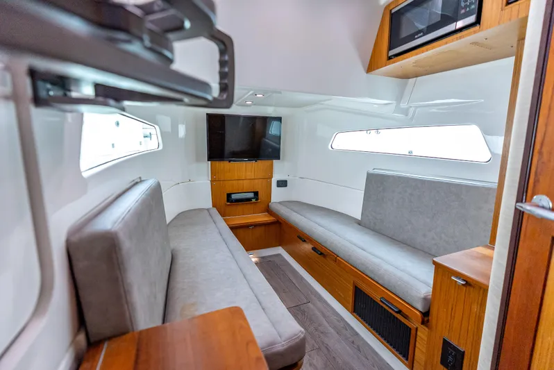 Two Roads Yacht Photos Pics 2021 Solace 41CS cabin interior with modern seating, TV, and wood accents.