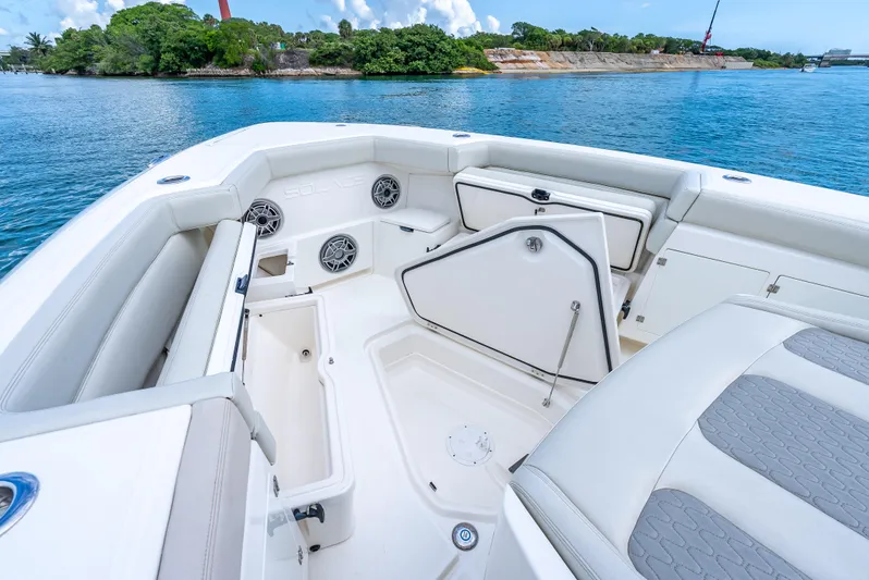 Two Roads Yacht Photos Pics Luxurious 2021 Solace 41CS boat interior with seating and storage, docked by scenic shoreline.