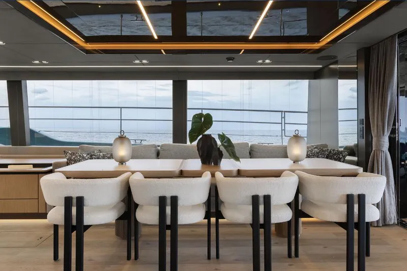  Yacht Photos Pics Luxurious interior of 2025 Sunreef Yachts 80 Eco, featuring elegant dining area with ocean view.