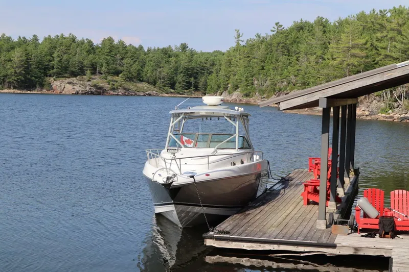  Yacht Photos Pics 2008 Donzi 38 ZSF boat docked by a scenic lakeside with red chairs.
