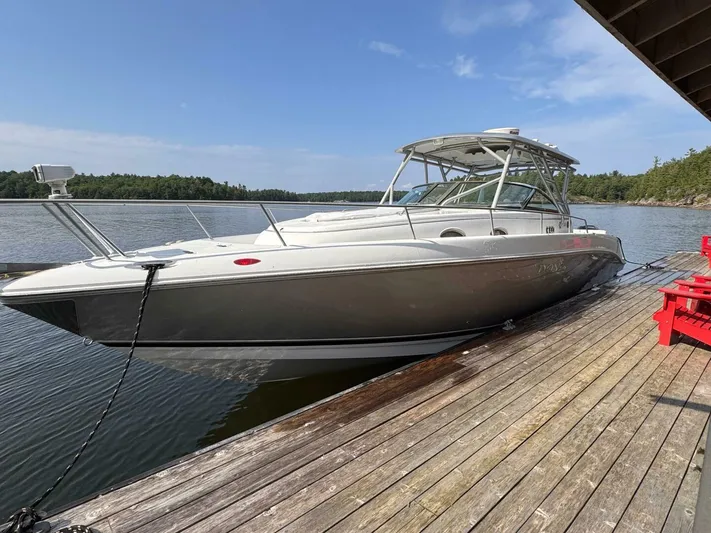  Yacht Photos Pics 2008 Donzi 38 ZSF boat docked on a wooden pier, surrounded by scenic water and trees.