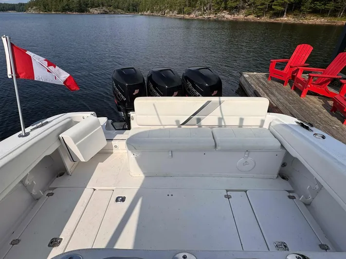  Yacht Photos Pics 2008 Donzi 38 ZSF boat with Canadian flag, docked near red chairs on a lake.