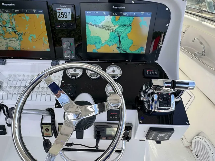  Yacht Photos Pics Control panel of a 2008 Donzi 38 ZSF boat with navigation screens and steering wheel.