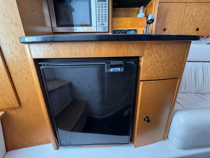  Yacht Photos Pics 2008 Donzi 38 ZSF interior with microwave, fridge, and wooden cabinetry.