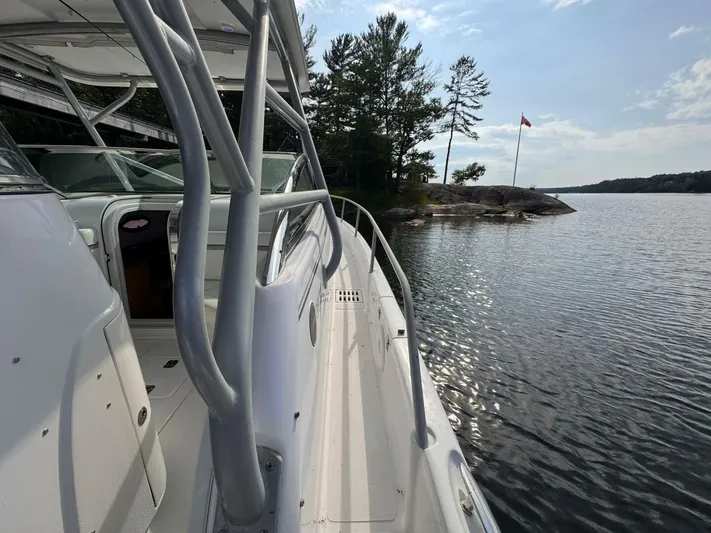  Yacht Photos Pics 2008 Donzi 38 ZSF boat docked by a scenic lakeside with trees and a flag.