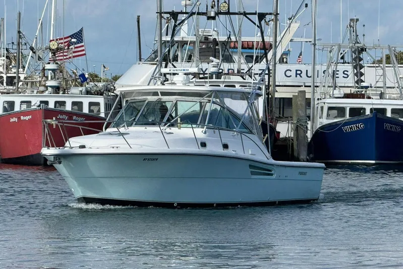Valkyrie Yacht Photos Pics 2004 Pursuit 3400 Offshore boat docked near fishing vessels in a marina.