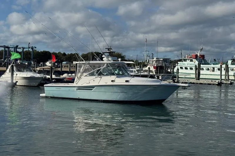 Valkyrie Yacht Photos Pics 2004 Pursuit 3400 Offshore boat docked in a marina under cloudy skies.